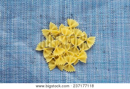 Farfalle Raw Farfallini A Handful Of Macaroni On A Rustic Blue Textured Background. A View From The 