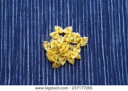 Farfalle Raw Farfallini A Handful Of Macaroni On A Rustic Striped White Blue Textured Background. A 