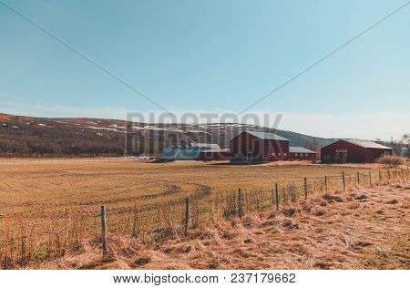 Field And Some Sort Of Small Farm In Northern Norway On A Sunny Day