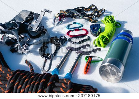 Close-up Of Winter Climbing Equipment On Fresh Snow On A Sunny Day. Carbines With A Rope Gazebo And 