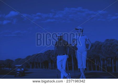 portrait of happy young  couple on golf course duo tone