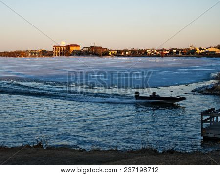 Bemidji, Minnesota - April 19 2018: Fishing Boat Near Ice On Frozen Lake Bemidji At Sunset Minnesota