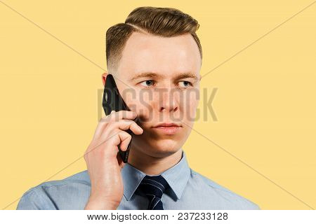 Young Businessman Dressed In Blue Shirt And Tie, Isolated On Beige Background