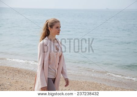 Blonde Girl Walks Along The Beach Of The Sea Coast 1