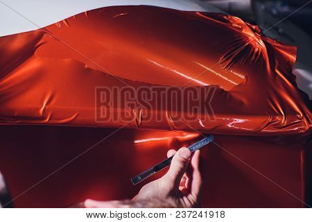 Car Wrapping Specialist Putting Vinyl Foil Or Film On Car. Selective Focus.