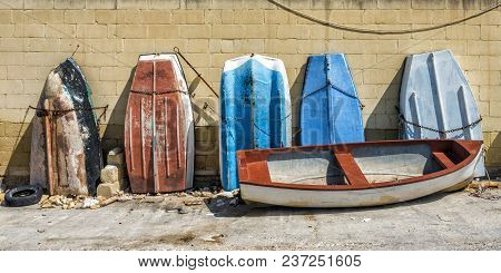 A Row Of Old Boats Stood On End In A Boatyard In Valletta, Malta