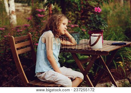 Happy Romantic Child Girl Dreaming In Evening Summer Garden Decorated With Candle Holder.