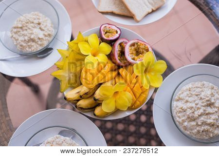 Delicious Home Breakfast Served For Three Person. Oatmeals Porrige And Fruit Bowl With Mango, Banana
