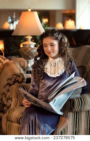 Maiden Student In A Retro Dress With A Jabot Sits In An Antique Chair And Reads A Newspaper Pensivel