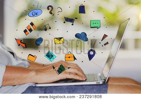 Side View Of Young Man Using Laptop Placed On His Lap. Blurry Outdoor Background With Social Media S