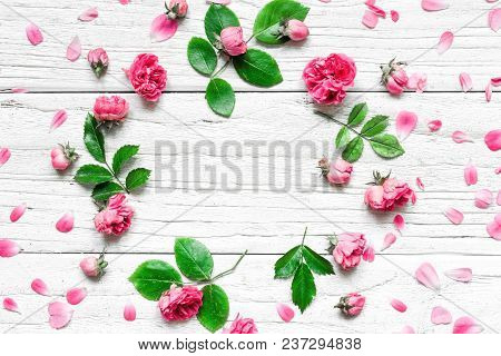 Flowers Composition. Frame Made Of Fresh Rose Flowers On White Wooden Background. Flat Lay. Mock Up.