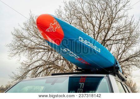 Fort Collins, CO, USA - April 7, 2018: A racing stand up paddleboard by Starboard (2018 All Star model) on roof racks of Toyota 4Runner.