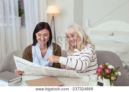 Breaking News. Enthusiastic Elder Woman And Caregiver Reading News And Laughing