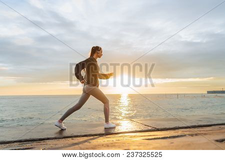 Zealous Slender Girl Runs Around The Seaside At Sunset, Leads An Active And Healthy Lifestyle