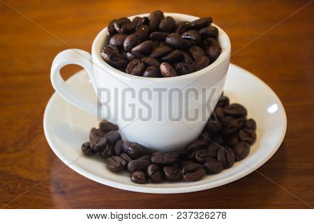 Coffee Cup Or Coffee Beans On Wooden Table, Stock Photo