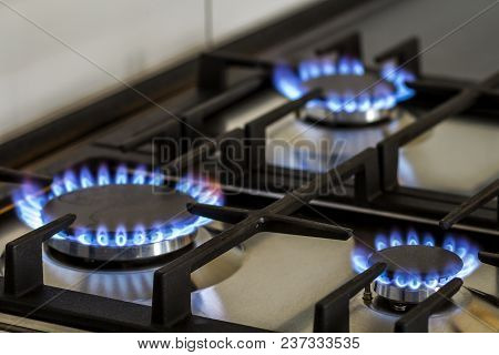 Natural Gas Burning On Kitchen Gas Stove In The Dark. Panel From Steel With A Gas Ring Burner On A B