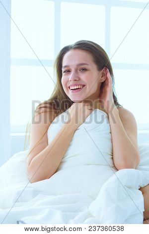 Young caucasian woman covering her head and ears with pillows