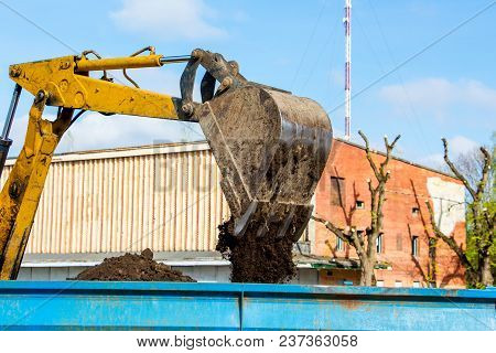 Improvement Of  City. Excavator Bucket  Pours  Earth Onto Tractor Traileris