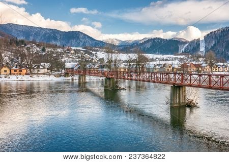 Slovak Village Of Nezbudska Lucka Near Strecno In The Winter, River The Vah With The Bridge In The F