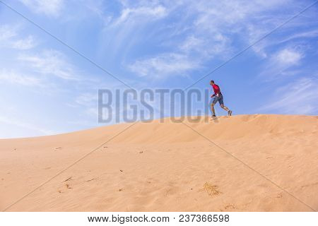 A Man Runs Up The Sand Dune In The Wadi Araba Desert, Jordan
