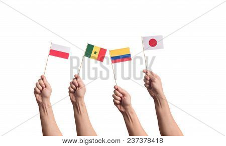 Little Paper National Flags In Hands Isolated On White Background. Flags Of National Football Teams 