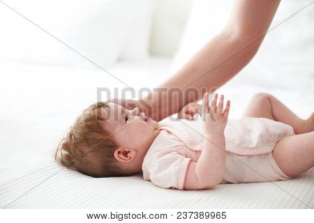 Six Month Baby On Bed Playing With Father. Happy Family Concept