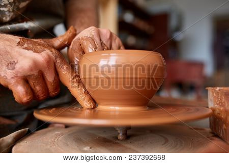 Close-up Hands Of A Male Potter In Plaid Shirt And Dirty Apron Who Molds A Vase From Clay, Selective