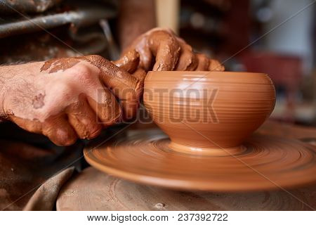 Close-up Hands Of A Male Potter In Plaid Shirt And Dirty Apron Who Molds A Vase From Clay, Selective