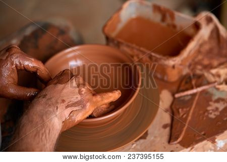 Close-up Hands Of A Male Potter In Plaid Shirt And Dirty Apron Who Molds A Vase From Clay, Selective