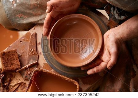 Close-up Hands Of A Male Potter In Plaid Shirt And Dirty Apron Who Molds A Vase From Clay, Selective