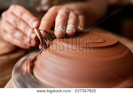 Close-up Hands Of A Male Potter In Plaid Shirt And Dirty Apron Who Molds A Vase From Clay, Selective