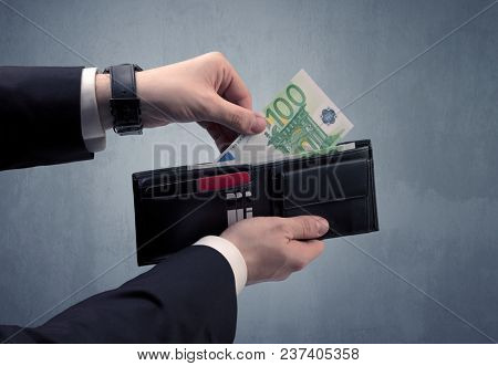 Businessman's hand in suit takes out eruo from his wallet