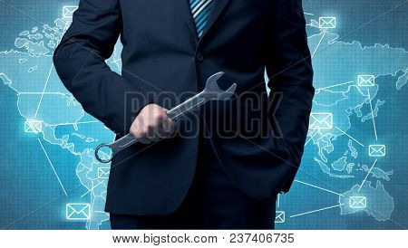 Businessman holding tool with global map graphic on the background