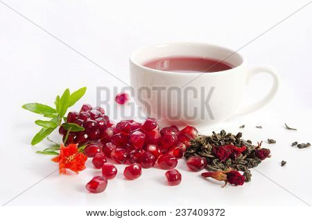 Parts Of A Pomegranate With Pomegranate Seeds And Leaves, Flowers, Dry Tea Of Carcade And Full Cup O