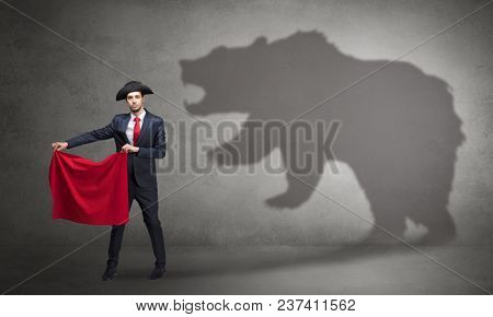 Businessman standing with red cloth in his hand and big bear shadow on his background