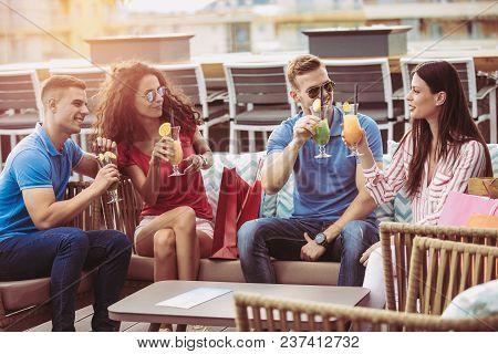 Friends Having Fun And Drinking Cocktails Outdoor On A Penthouse Balcony