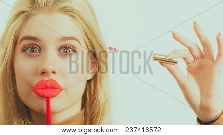 Young Adult Woman Applying Lipstick Or Lip Gloss, Getting Her Make Up Done Holding Fake Lips On Stic