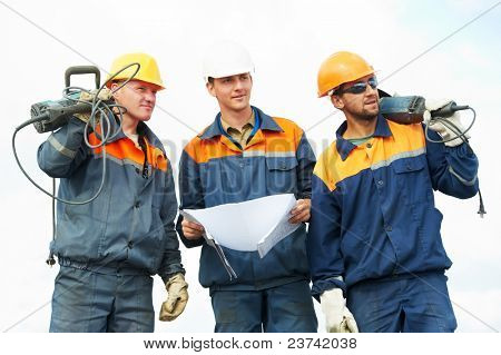 positivo operaio Builder con martello pneumatico trapano attrezzature sopra cielo blu