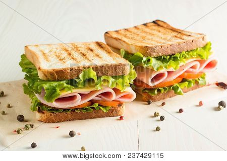 Close-up Photo Of A Club Sandwich. Sandwich With Meet, Prosciutto, Salami, Salad, Vegetables, Lettuc
