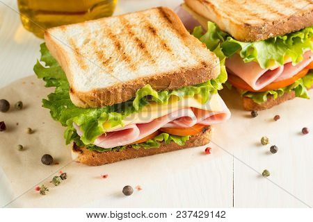 Close-up Photo Of A Club Sandwich. Sandwich With Meet, Prosciutto, Salami, Salad, Vegetables, Lettuc