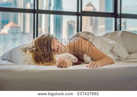Woman Wakes Up In The Morning In An Apartment In The Downtown Area With A View Of The Skyscrapers. L