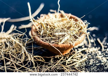 Dried Vetiver Grass Or Khus Or Chrysopogon Zizanioides Grass In A Clay Bowl On Wooden Surface.