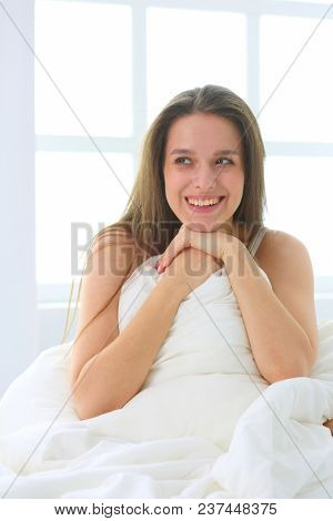 Young caucasian woman covering her head and ears with pillows