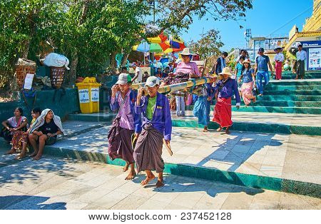 Kyaiktiyo, Myanmar - February 16, 2018: The Porters Carry The Elderly Buddhist Devotee On Stretchers