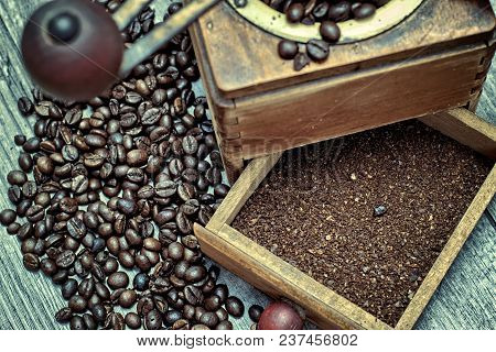 Old Coffee Grinder With Ground Coffee, Coffee Beans On A Wooden Background.