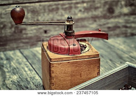 Old Coffee Grinder With Ground Coffee, Coffee Beans On A Wooden Background.