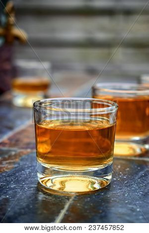 Alcohol,taste And Drink Concept-glasses With Whiskey,old Glass Barrel On Stone Table And Wooden Back