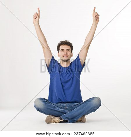 Nice Boy Sitting And Pointing Up By Fingers