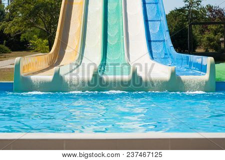 Water Park With Colorful Water Slides And Blue Swimming Pool