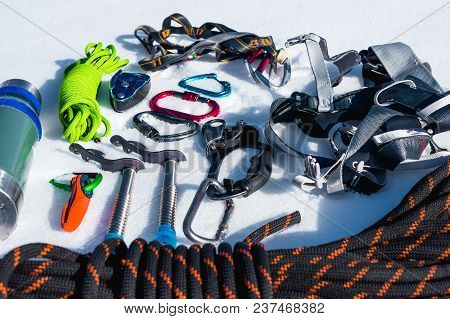 Close-up Of Winter Climbing Equipment On Fresh Snow On A Sunny Day. Carbines With A Rope Gazebo And 
